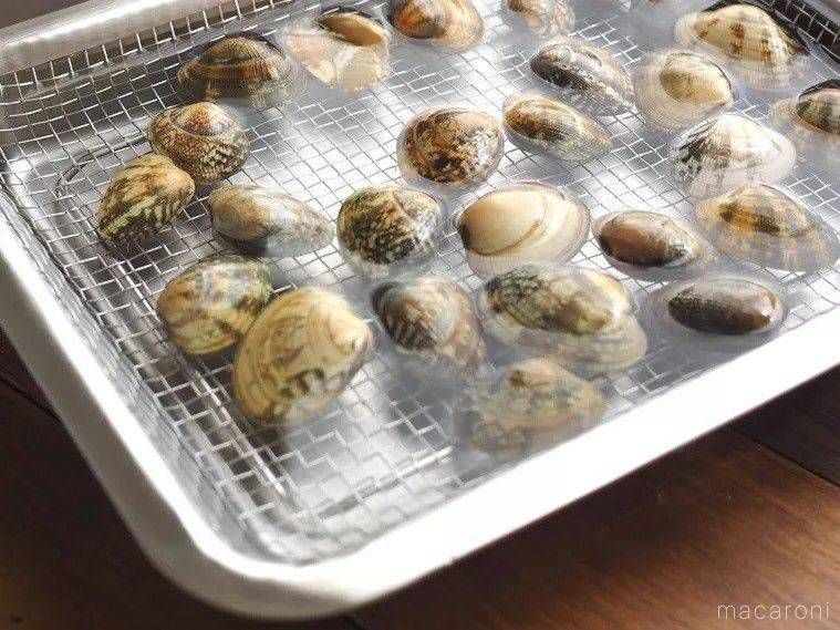 トレーに殻付きあさりを入れて下処理する様子