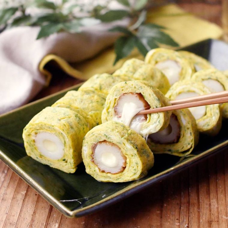 黒い皿に盛りつけられたちくわの磯辺ロールたまご焼き