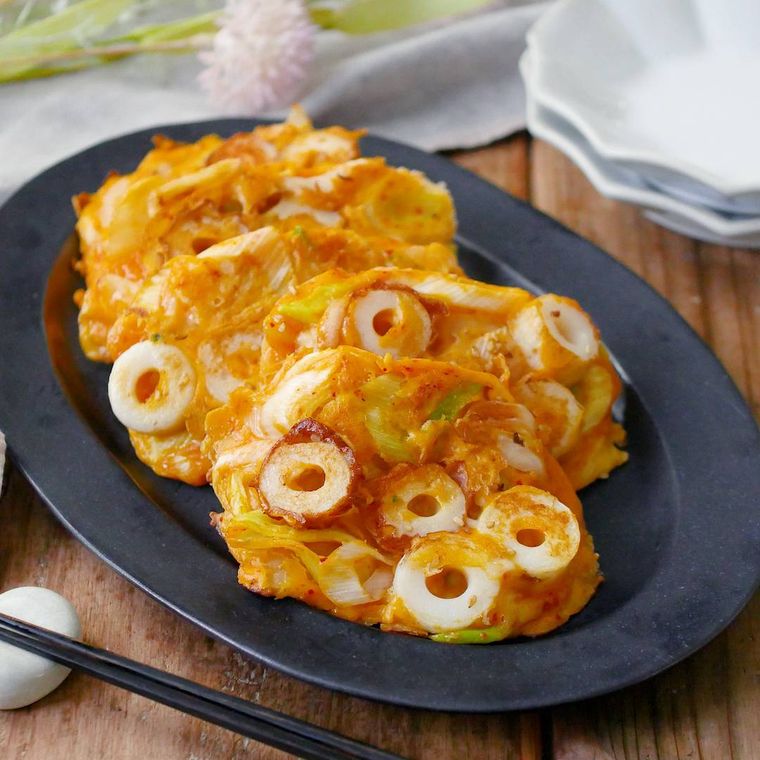黒い皿に盛りつけられたちくわのキムチーズチヂミ