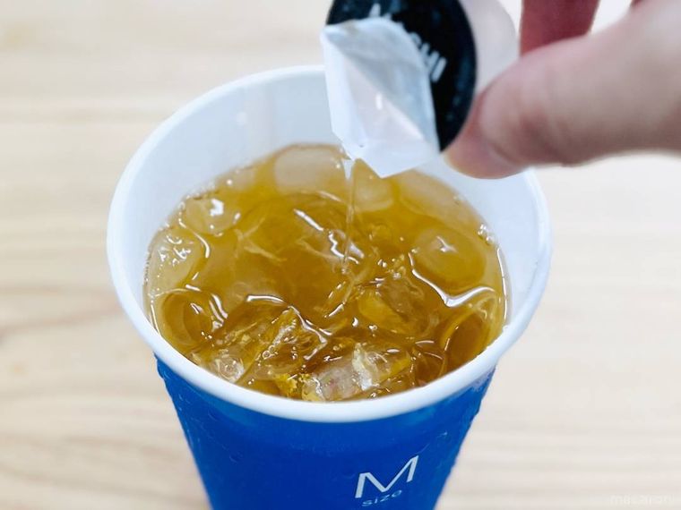 ローソンのアイスゆずシトラスティーにガムシロップを入れている様子