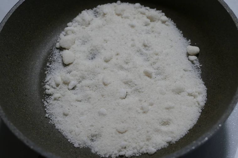 固まった塩をフライパンで炒る様子