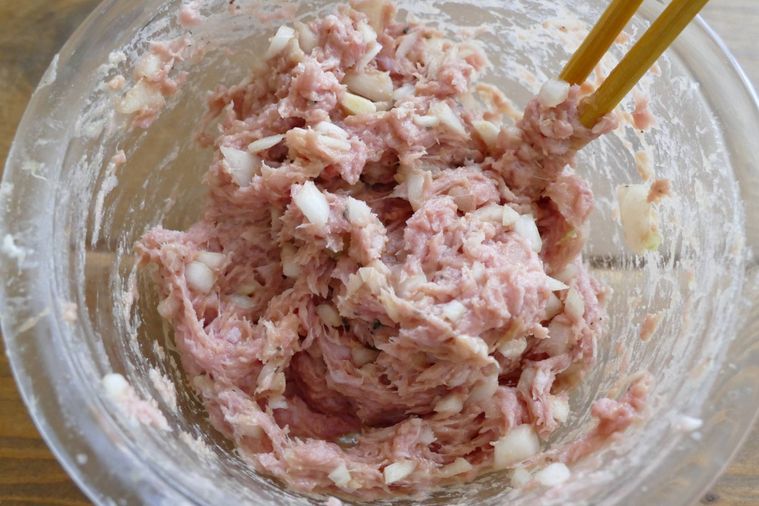 箸で肉だねを混ぜる様子