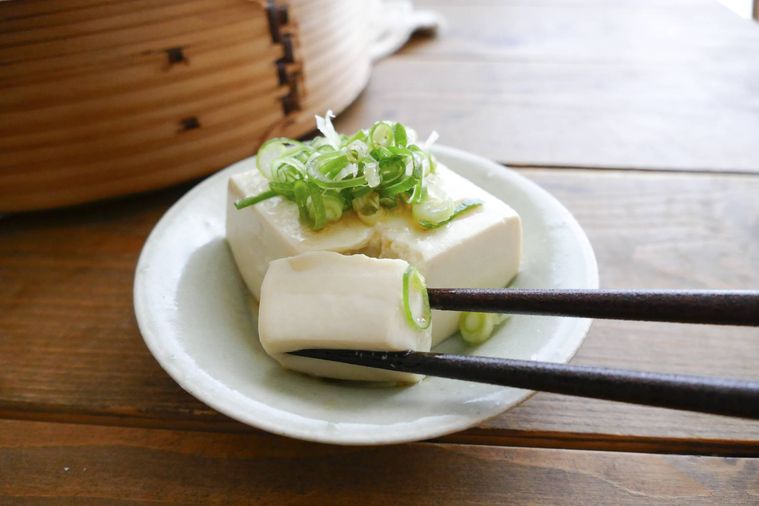 せいろ蒸し豆腐を箸で切って持ち上げようとする様子