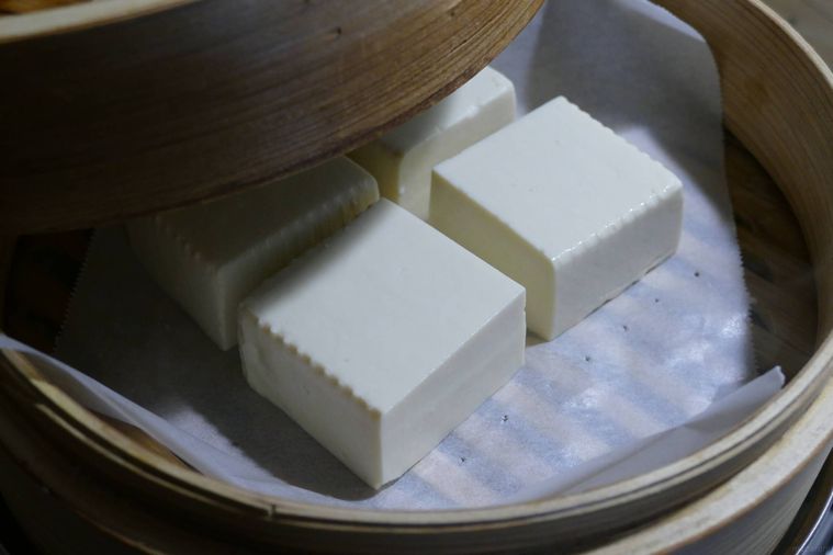クッキングシートに豆腐をのせてせいろで蒸す様子