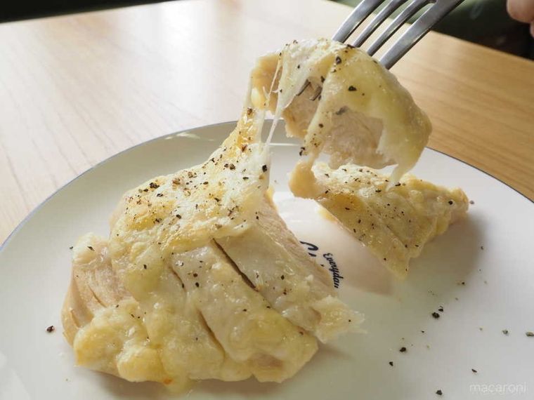 チーズをのせて焼いたサラダチキンを、フォークでさして持ち上げる様子