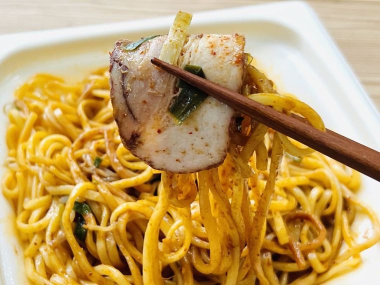 鬼金棒監修 カラシビ焼き味噌らー麺の麺とチャーシューを箸で持ち上げている様子