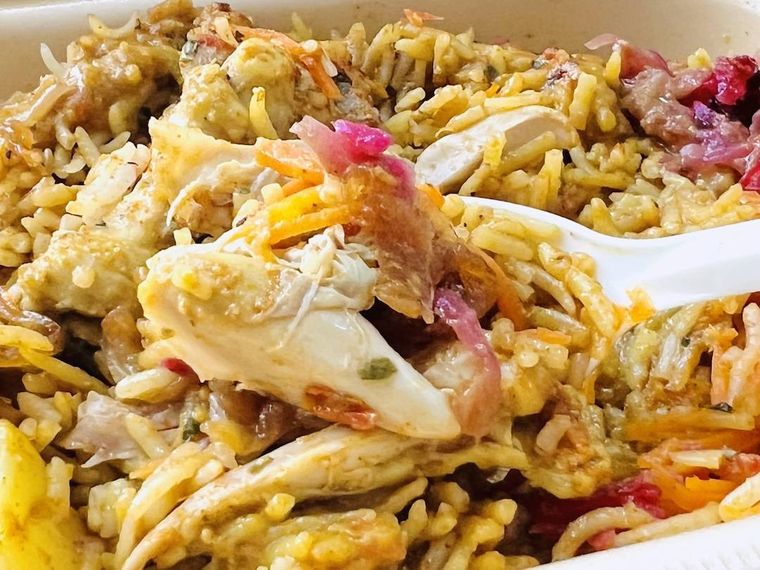CAFE BOX 骨付きチキンビリヤニをスプーンですくった様子