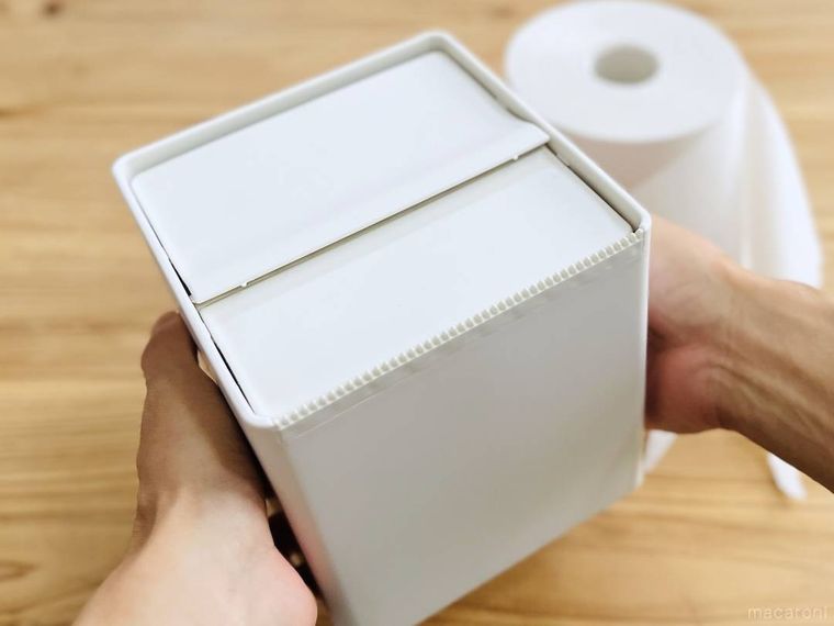 無印良品の卓上用 トイレットペーパーケースを両手で持ち上げている様子