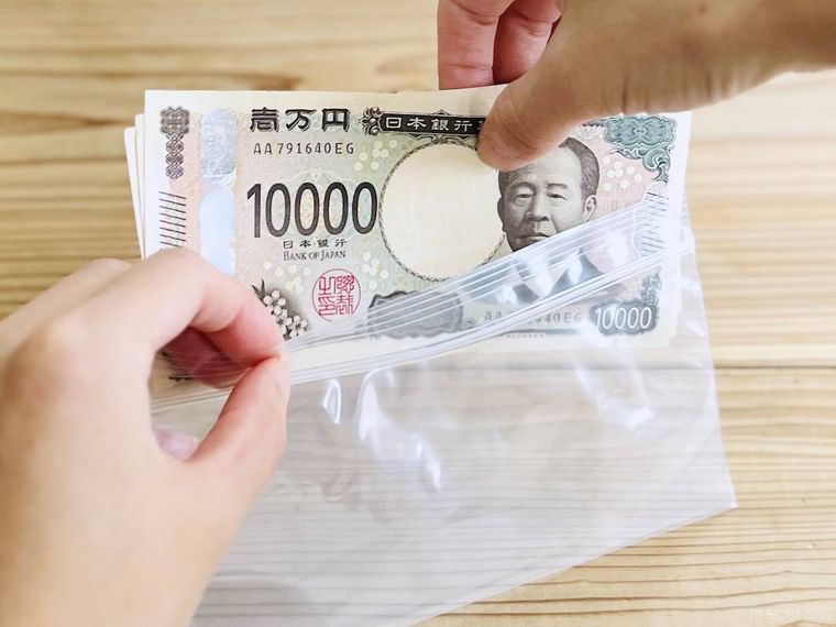 ダイソーのお札サイズ チャック付ポリ袋にお札を入れている様子