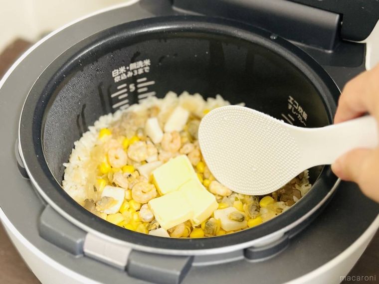 炊きあがったあさりコンソメ炊き込みごはんをかき混ぜようとしている様子