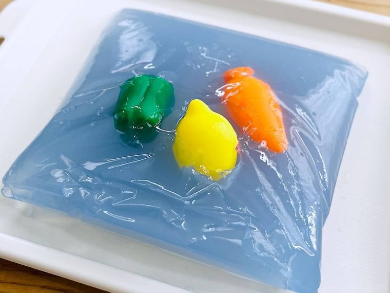 水色の寒天液におもちゃを入れて冷やし固めた様子