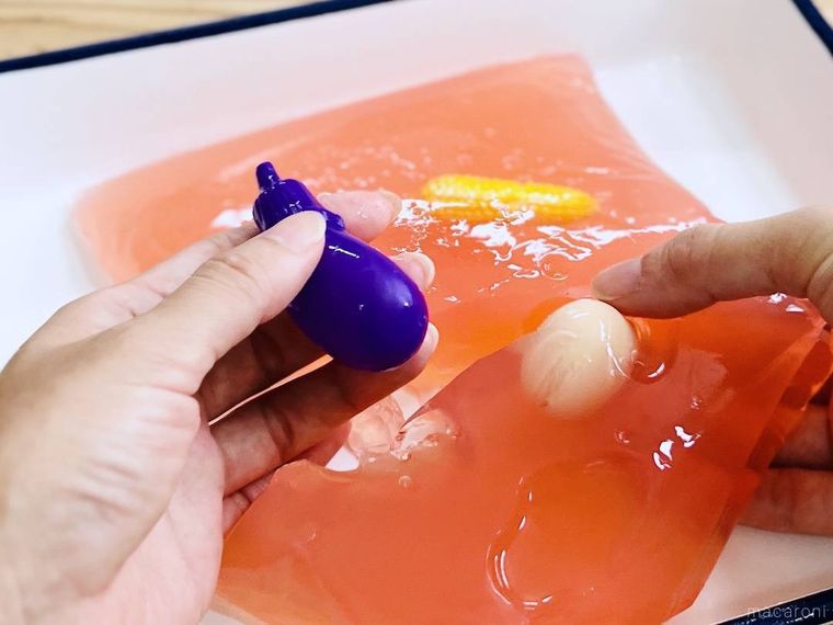 ピンク色の寒天からなすのおもちゃを取り出している様子