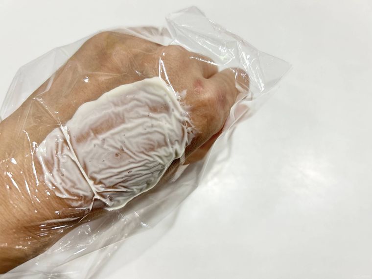 手の甲に酒かすパックをパッチテストしている様子