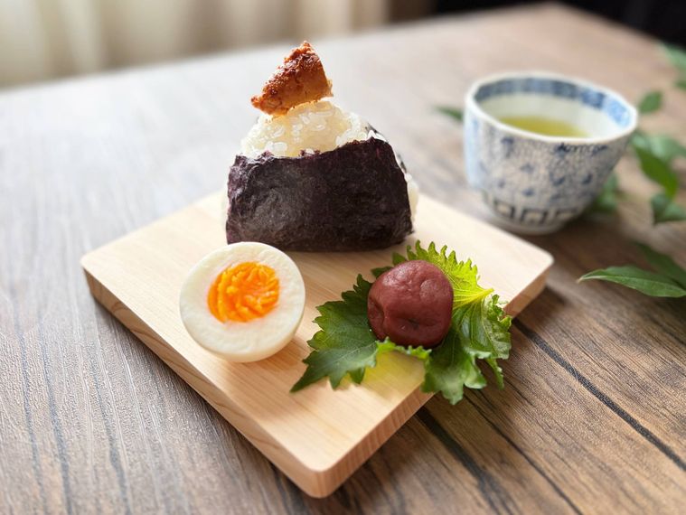 朝のまな板におにぎり、ゆで卵、梅干しをのせた様子