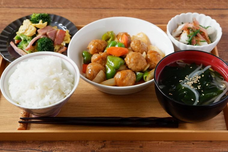 木のトレーにのせた肉団子の酢豚風定食
