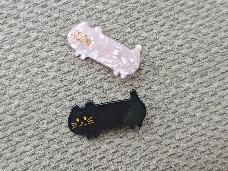 アクリルヘアクリップ ねこ2Pが机の上に置いてある