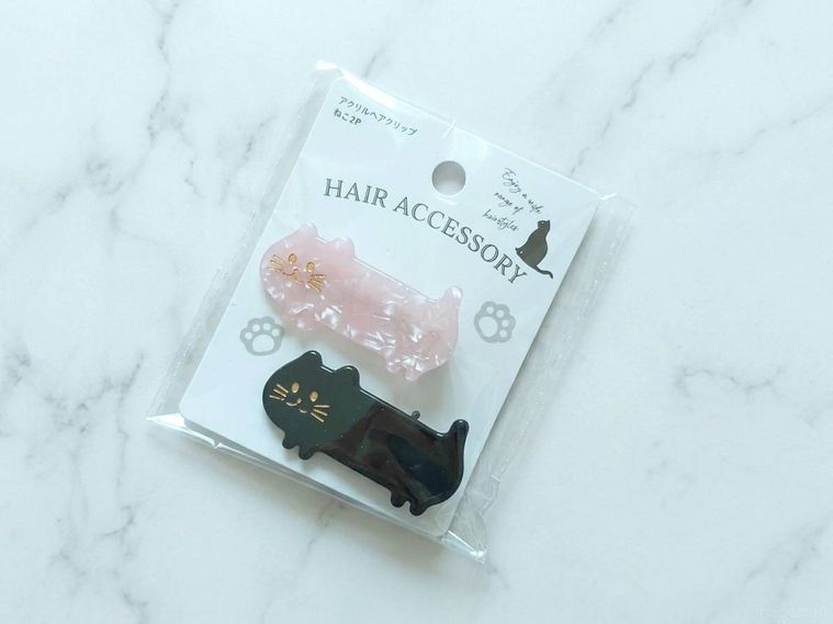 アクリルヘアクリップ ねこ2Pが机の上に置いてある