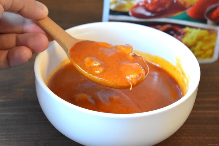 西友のみなさまのお墨付き 完熟トマトとバターのコク バターチキンカレーをスプーンですくっている