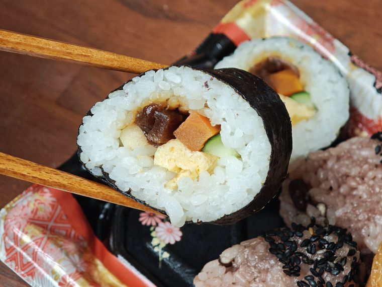 赤飯助六寿司華のお寿司を箸でとっている様子