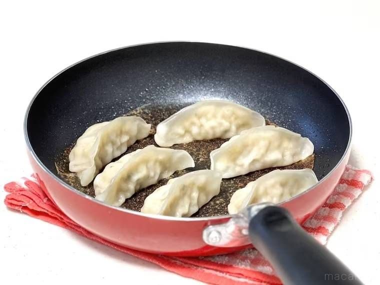 餃子が焦げ付いたフライパンを濡れ布巾の上にのせた様子