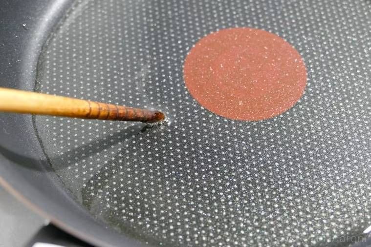 フライパンの油の温度を菜箸で確かめている様子