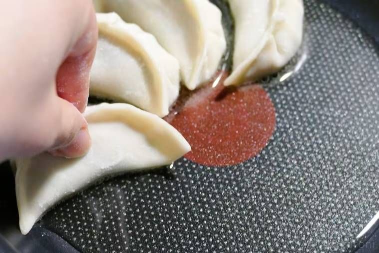 フライパンに餃子を並べている様子