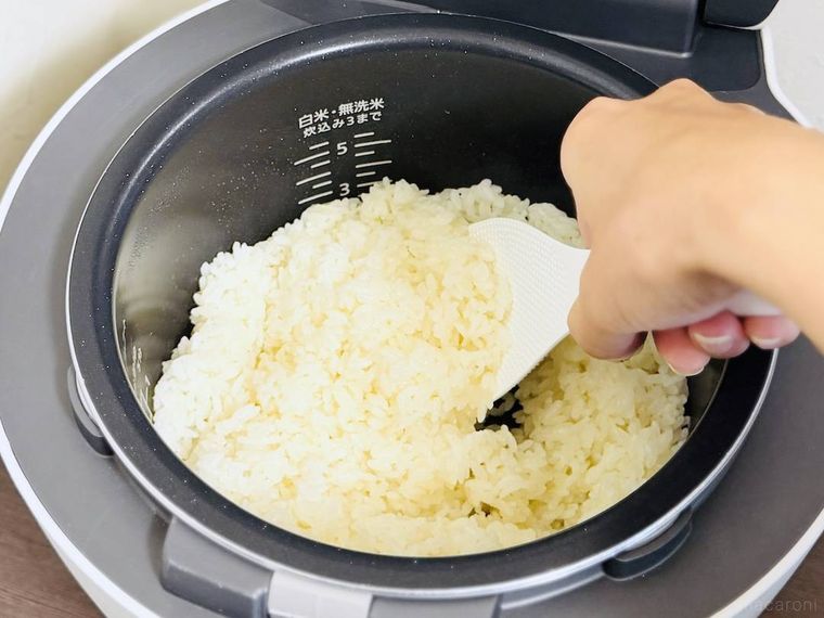 炊飯器で炊いたバターライスをしゃもじで混ぜている様子