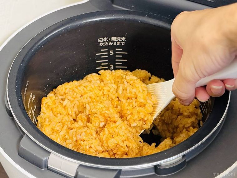 炊飯器で炊いたチキンライスをしゃもじで混ぜている様子