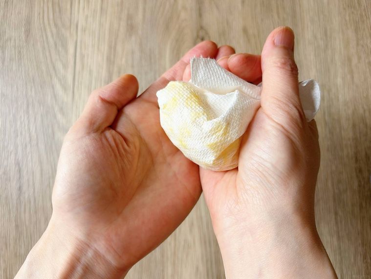 キッチンペーパーに包んだたくあんを軽く絞る様子