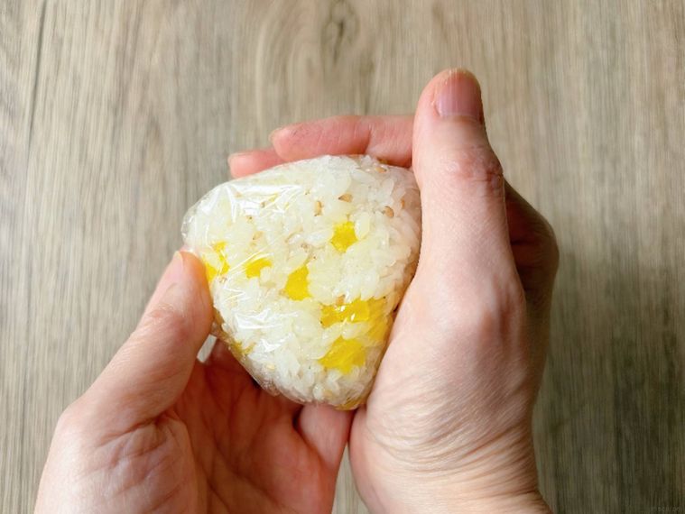 たくあんおにぎりをやさしく握る様子