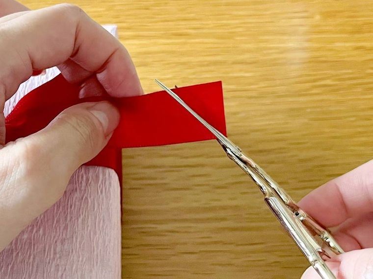 リボンの端を斜めにカットしている様子