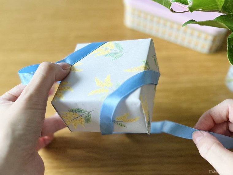 箱の裏にリボンを通している様子