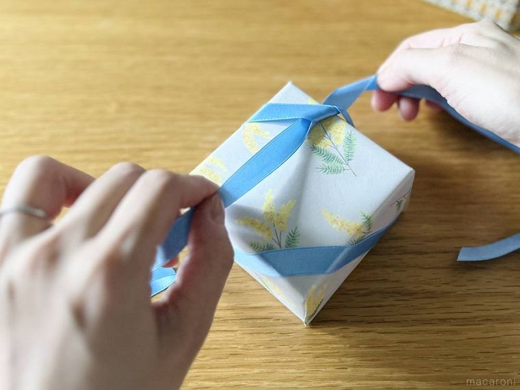 箱の角でリボンを結んでいる様子