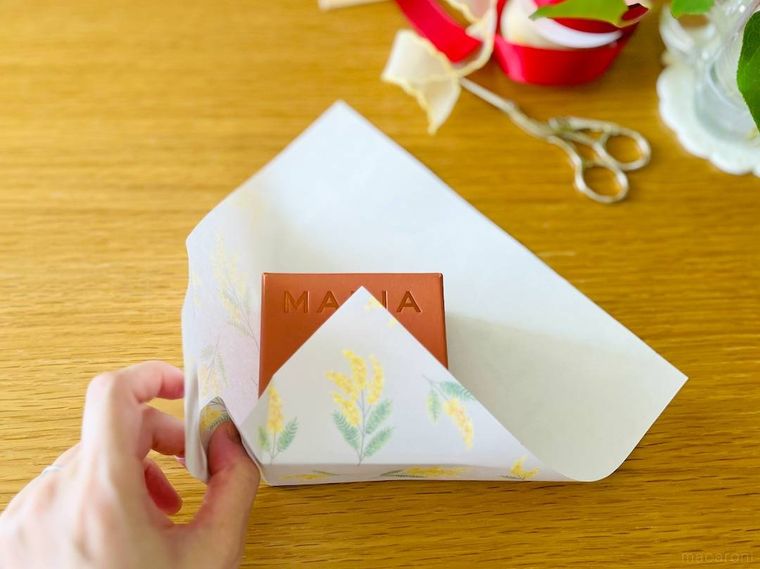 ラッピング用紙を箱に沿わせて折っているところ