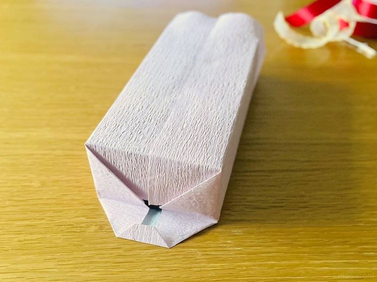 ラッピングした箱の側面を整えているところ