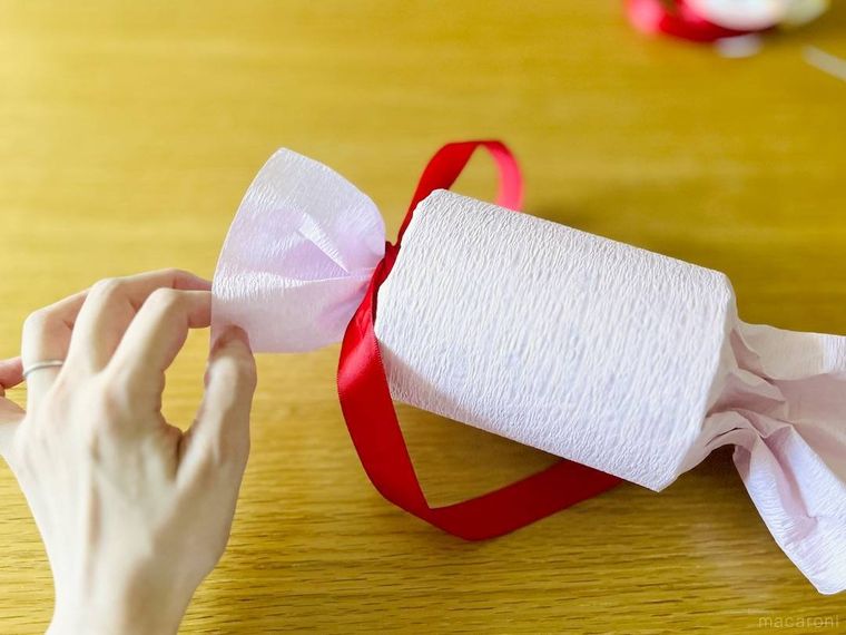 筒の片方をリボンで縛っているところ