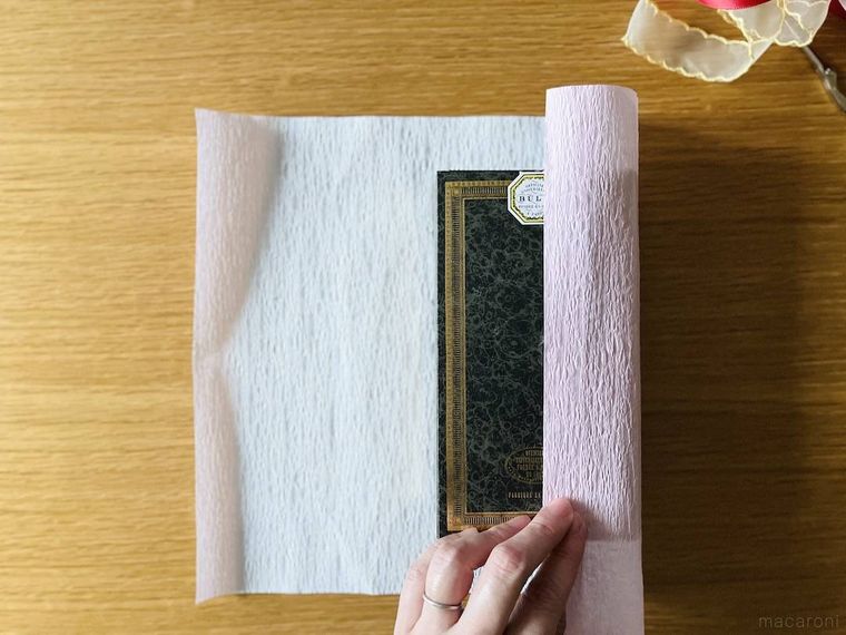 ラッピング用紙の両端を箱の中央で合わせている様子