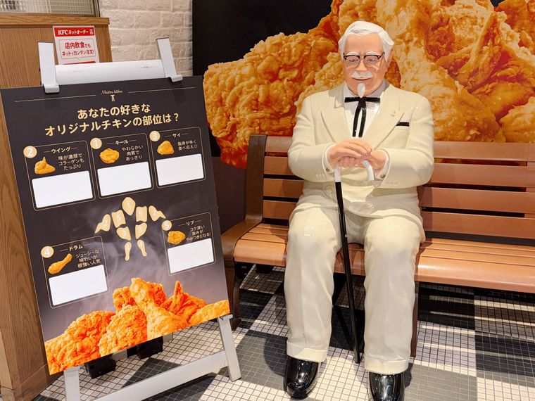 カーネルサンダーの置き物と、チキンの部位の紹介ポスター