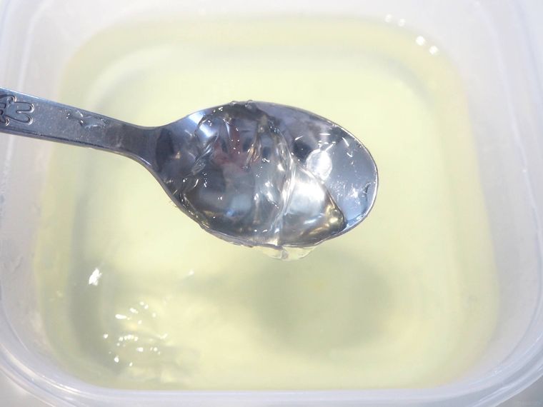 黄色の寒天液をスプーンですくっている様子