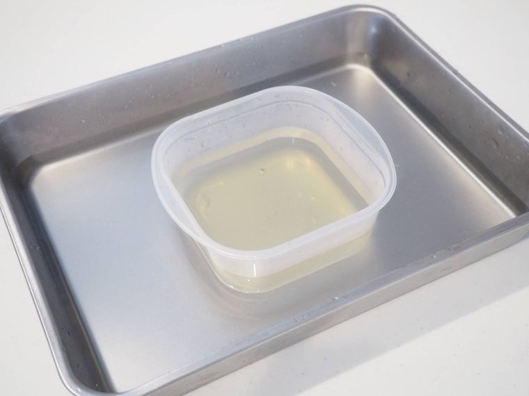 バットに入れた水で寒天液を入れた容器を冷やしている様子