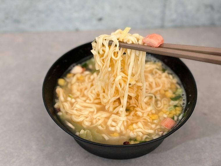 お椀に入った麺を箸で上げる様子
