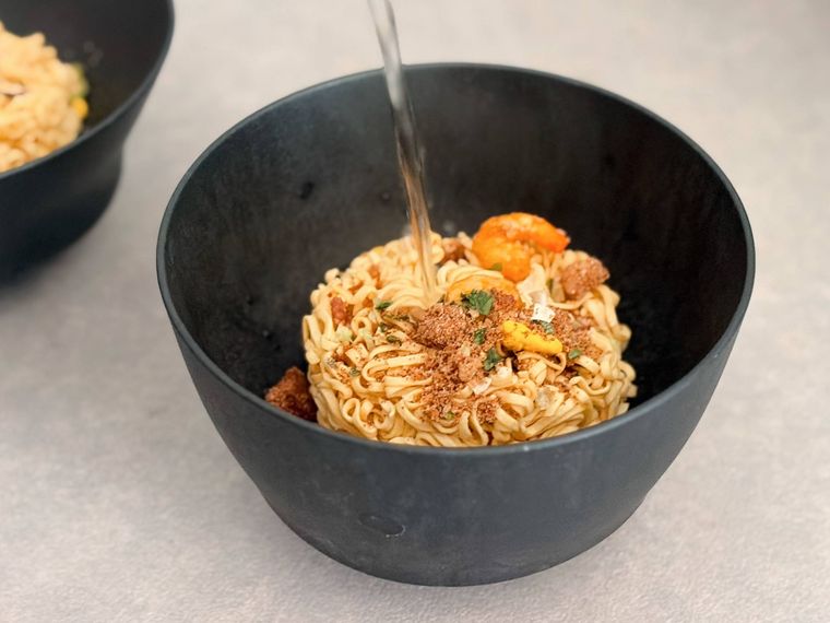 お湯が注がれている麺の入ったお椀