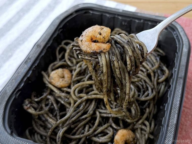 魚介と完熟トマトの旨み イカスミパスタをフォークですくった様子