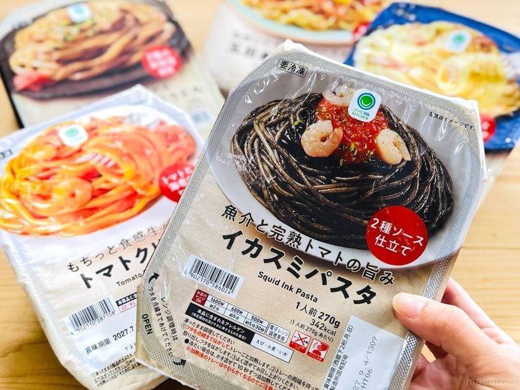 ファミリーマートの魚介と完熟トマトの旨み イカスミパスタを手で持っている様子