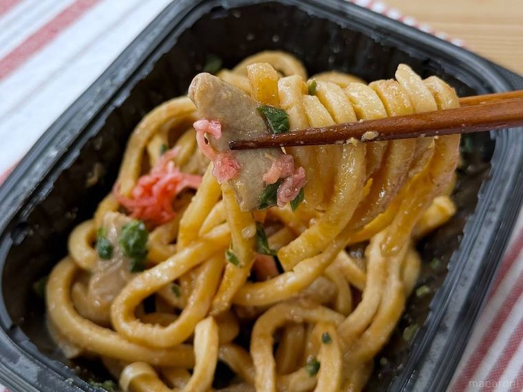 濃厚なコクが広がる 牛ホルモン味噌焼きうどんを箸で持ち上げている様子