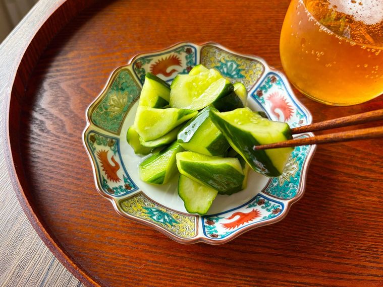 和皿に盛られたきゅうりのビール漬けを箸あげする様子