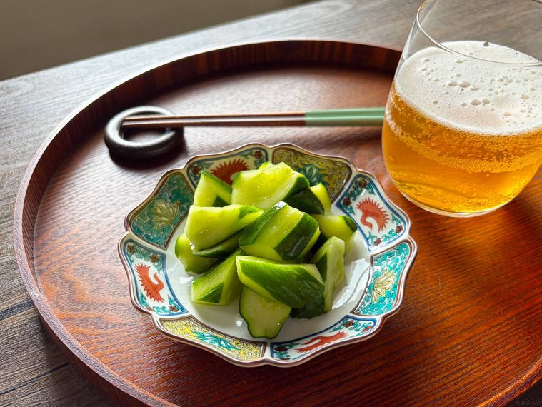 和皿に盛られたきゅうりのビール漬けを箸あげする様子