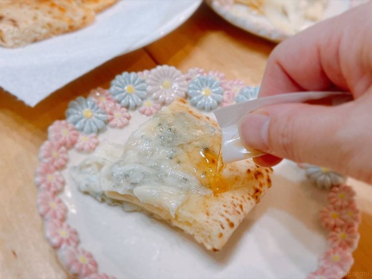 コストコのチーズとはちみつのピザにはちみつをかけて食べる様子