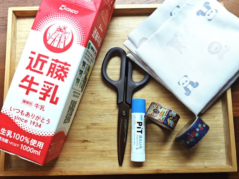 牛乳パックのペン立てに必要な材料が机の上に置いてある