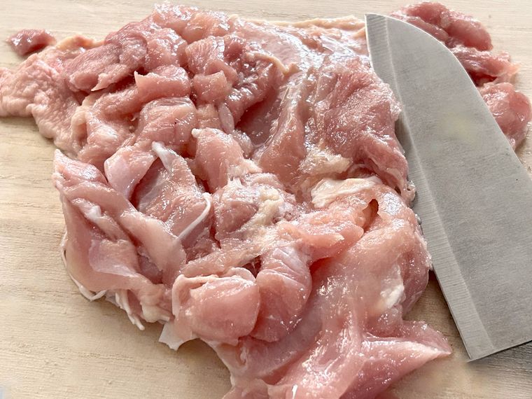 鶏もも肉に包丁で切り目を入れているところ